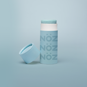 Nöz's light blue sunscreen stick in front of a baby blue background.