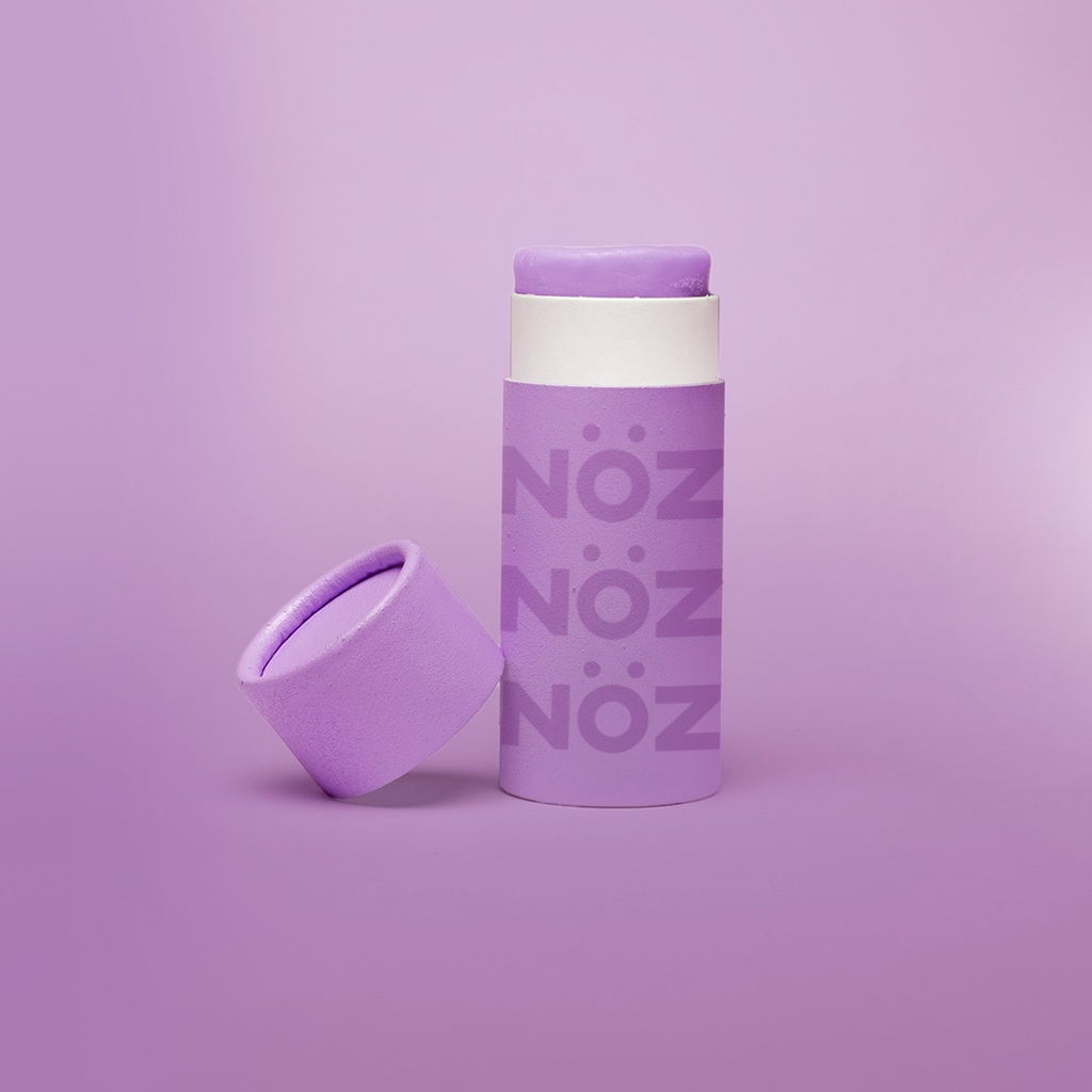 Nöz's purple sunscreen stick in front of a lavender background.